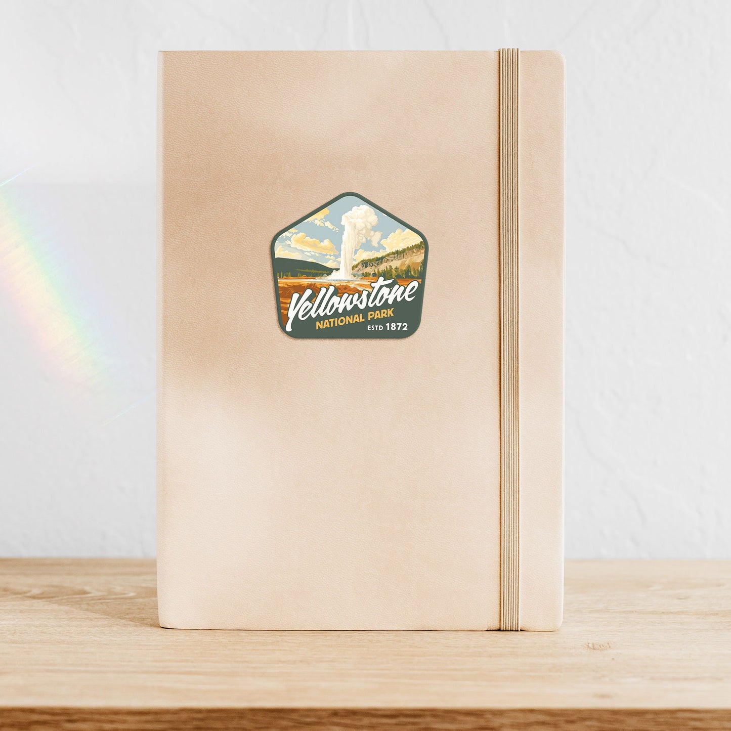 Waterproof vinyl sticker of Yellowstone National Park adorns notebook, showcasing stunning mountain art, ideal for nature lovers. Gloss laminated to make a durable sticker.